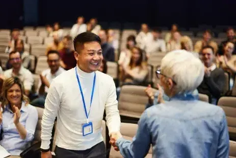 two people shaking hands at a conference event